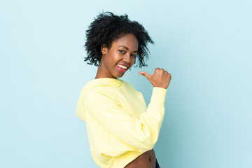 Young African American woman isolated on blue background proud and self-satisfied