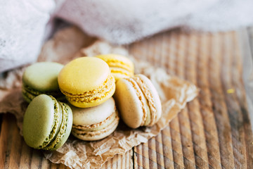 Macarons saveur vanille pistache et citron sur une table en bois