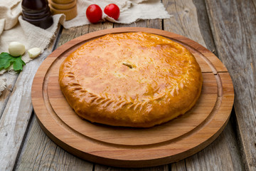 Ossetian pie with meat on wooden table