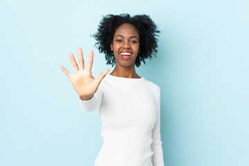 Young African American woman isolated on blue background counting five with fingers