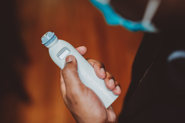 African american man using a temporal thermometer to record his temperature by running it across...