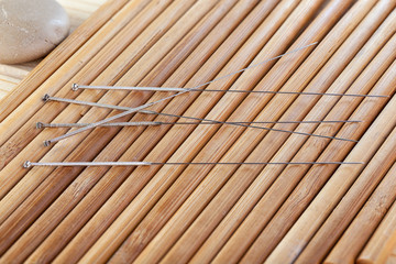 Table with needles for acupuncture. Silver needles for traditional Chinese acupuncture medicine on table. The full depth of cut.
