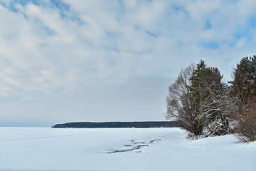 winter landscape. frozen river, forest, blue sky