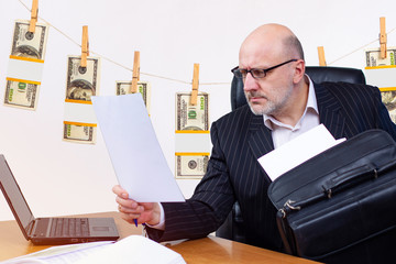 Money laundering. Man in the office is looking through documents. Concept - auditor has identified...