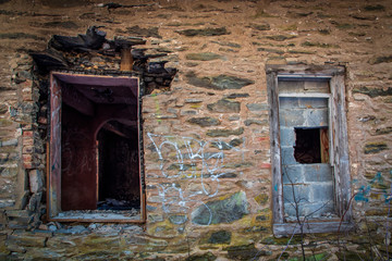 Old windows in an abandoned stone house