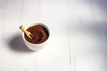 Recycling waste from coffee. Body scrub of ground coffee, homemade cosmetic for peeling and spa care on white background. Zero waste, eco friendly, reasonable consumption concept.