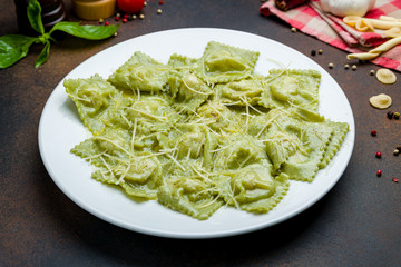 Green ravioli with spinach on white plate
