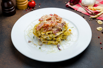 Fettuccine Carbonara with bacon and parmesan on a white plate
