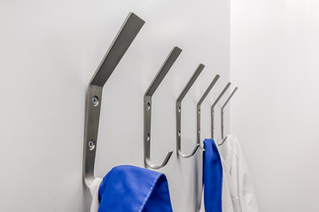 Hooks for medical clothes with hanging white and blue medical gowns