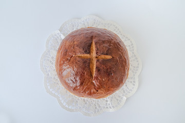 ZURICH, SWITZERLAND - APRIL 11, 2020: Homemade loaf of wheat bread with a cross is one of the traditional Easter christian dishes.