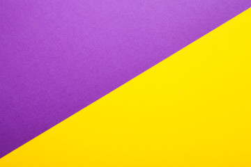 Purple and yellow paper as background. Two colored bright paper texture, top view with place for text