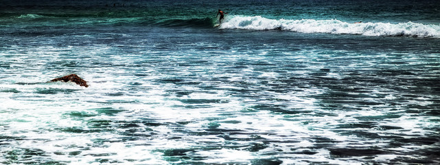 Naklejka premium surfer riding waves in Bali Indonesia water sport lessons waves in ocean