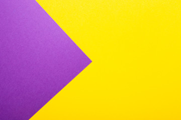 Purple and yellow paper as background. Two colored bright paper texture, top view with place for text