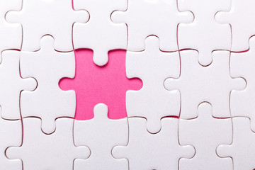 Fototapeta premium White puzzle background with one piece missing. Close-up. Concept success of business