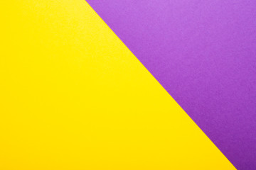 Purple and yellow paper as background. Two colored bright paper texture, top view with place for text