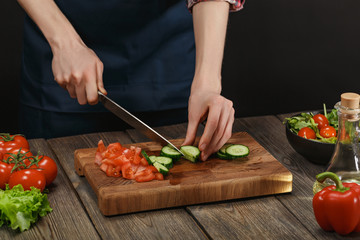 Woman cooking fresh vegetable salad. Female hands. Diet concept for healthy lifestyle with copyspace.