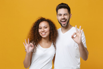 Funny couple two friends european guy african american girl in white t-shirts posing isolated on...