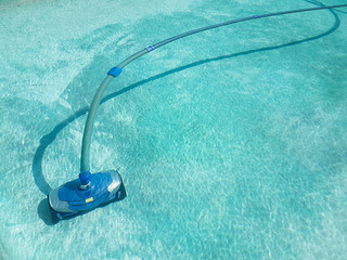 Automatic pool cleaner in an old swimming pool full of clean water