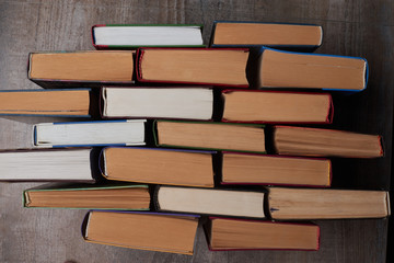 Many Books Piles. Hardback books on wooden table. Back to school. Copy space