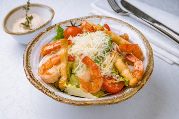 salad caesar with shrimps on white plate