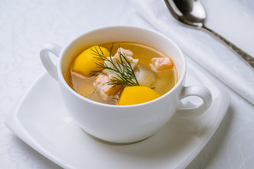 Fish soup with potatoes on white plate