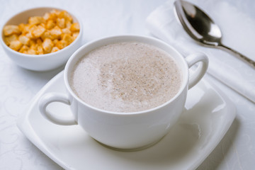 Cream soup of mushrooms on white table