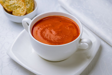 Soup cream of tomato on white plate