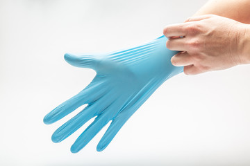 medical blue latex glove on the right female hand on a white background. Horizontal orientation.