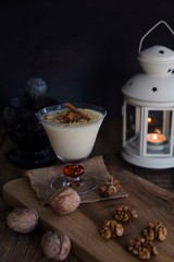  rice pudding on wooden background with candle and walnut