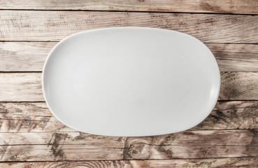Vintage Table setting with oval plate on old rustic wooden table. Minimal food concept.