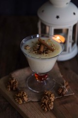  rice pudding on wooden background with candle and walnut