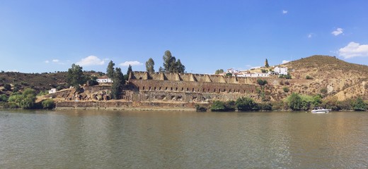 Fototapeta premium El Puerto de La Laja a orillas del río Guadiana en El Granado, Huelva, España. Las viejas paredes del antiguo puerto, ya en ruinas, donde se cargaba el mineral en los barcos para su transporte.