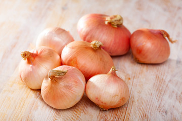 Fototapeta premium Onion bulbs on wooden background, nobody