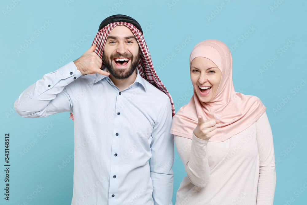 Wall mural funny couple friends arabian muslim man wonam in keffiyeh kafiya ring igal hijab clothes isolated on