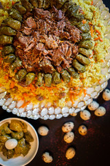 Traditional georgian dolma in grape leaves on black table with female hand