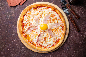 Carbonara pizza with bacon and egg on concrete table top view