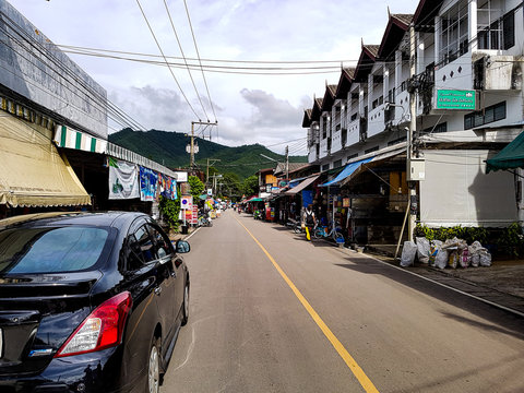 Car street road electricity cable mast houses village pai middle centre shops walking north chiang mai mountain green © Simon