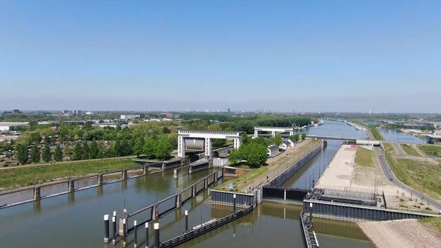 4k aerial video of Princess Beatrix sluice complex in the Netherlands with two inland vessels in the lock. Waterways transportation 