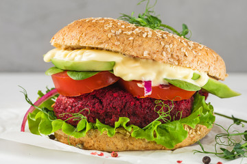 Veggie burger with beetroot and avocado on white marble table. Healthy vegan food