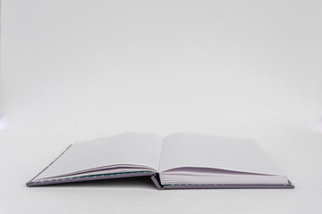 Open notebook isolated on white for background. Business, education, school, organization concept. Side view of a notebook.