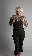 Tattooed Model. Young blonde woman with many tattoos wearing a body siut. Posing on a white background.