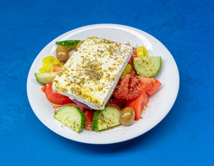 Greek salad plate with original feta cheese, olives, green pepper slices, tomatoes, onions and cucumber slices