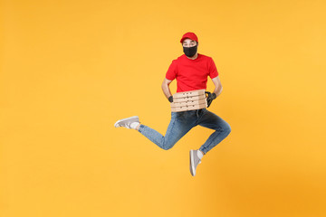 Fun jumping delivery man in red cap t-shirt uniform sterile face mask gloves isolated on yellow...