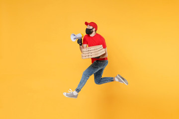Fun jumping delivery man in red cap t-shirt uniform sterile face mask gloves isolated on yellow background studio Guy employee courier Service quarantine pandemic coronavirus virus 2019-ncov concept.