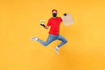 Fototapeta na wymiar Fun jumping delivery man guy employee in red cap mask gloves hold craft paper packet food coffee isolated on yellow background studio. Service quarantine pandemic coronavirus virus 2019-ncov concept.