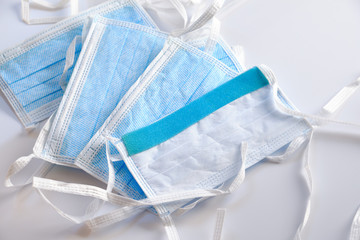 A stack of disposable face masks lying on white ground. Seen in Germany in April.