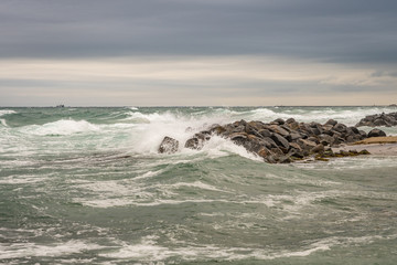 Troubled sea with sea spray on boulders near Skagen, Denmark
