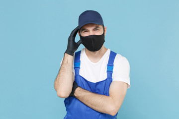 Delivery man in cap t-shirt coveralls uniform sterile face mask gloves isolated on blue background studio. Guy employee courier Service quarantine pandemic coronavirus virus covid-19 2019-ncov concept