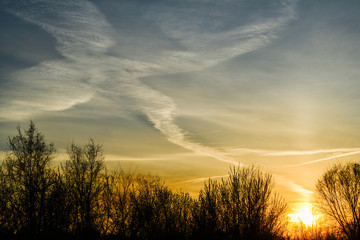 Fototapeta na wymiar Crossing condensation trails in the sunset sky