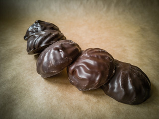 White marshmallows in chocolate on parchment paper